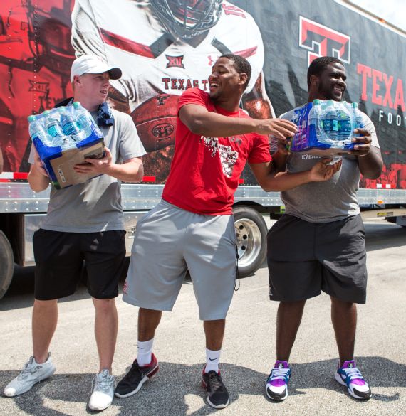 Mason McClendon, Kevrin Justice, Blake Young and Chantez Jackson pass water down an assembly line as they unload a Texas Tech truck full of donated supplies in Houston. Photo: Michael Starghill, Jr. for ESPN